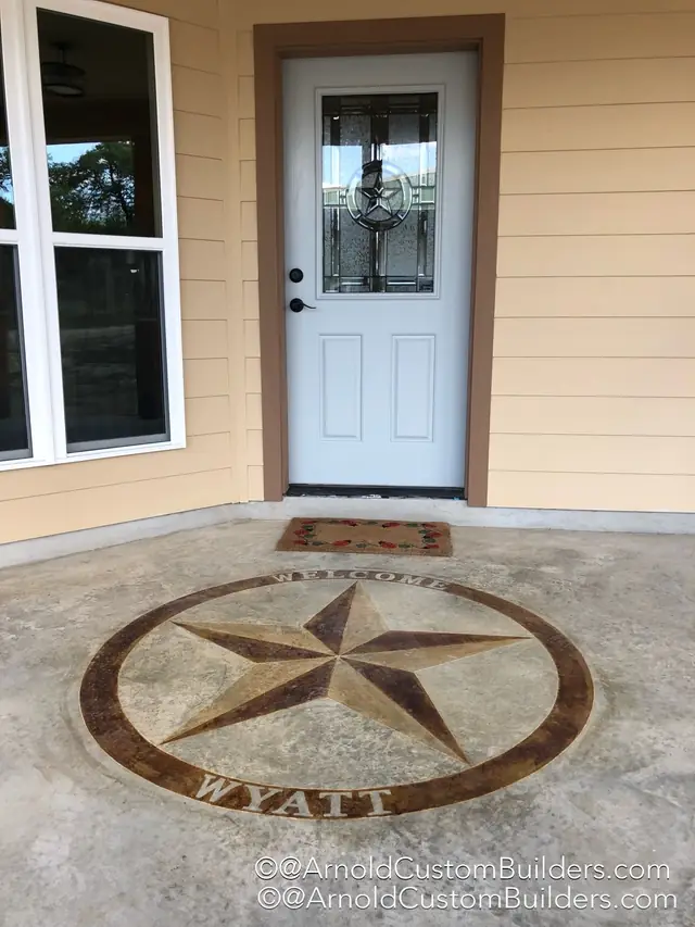 A custom stained concrete Texas star porch medallion beside a Dutch style front door with star transom glass